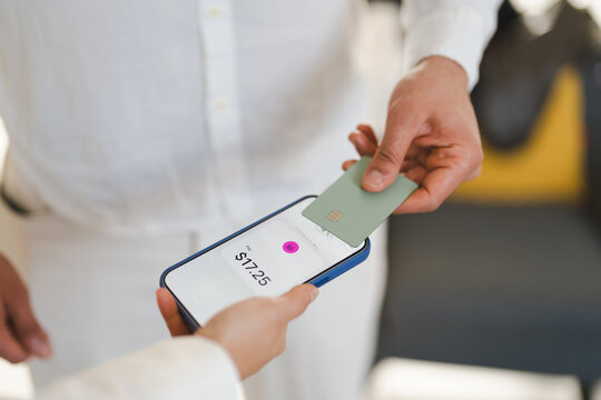 A person uses a credit card to tap and pay for a purchase of $17.25 on a mobile device.