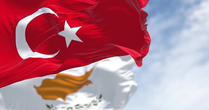 Turkish and cypriot national flags waving in the wind on a clear day