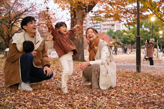 Family playing with leaves in autumn at Sumida park Tokyo