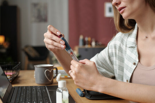 Woman checks blood glucose at home with glucose meter and insulin