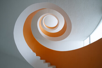 Fototapeta premium Spiral staircase with orange and white colors.