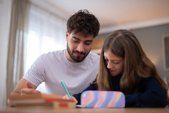 Father helping daughter with homework at home