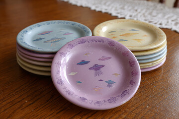 Colorful plates stacked on a wooden table.