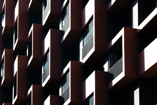 Modern urban architecture facade with windows pattern and shadows plus contrast and geometry forming an abstract background texture