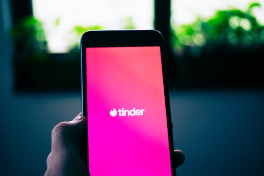 person opening tinder dating app on a phone