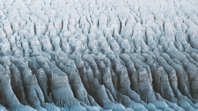 View of an expanse of stark, pale formations etched by time and weather, creating a landscape of ridges and shadows, Mangystau Region, Kazakhstan.