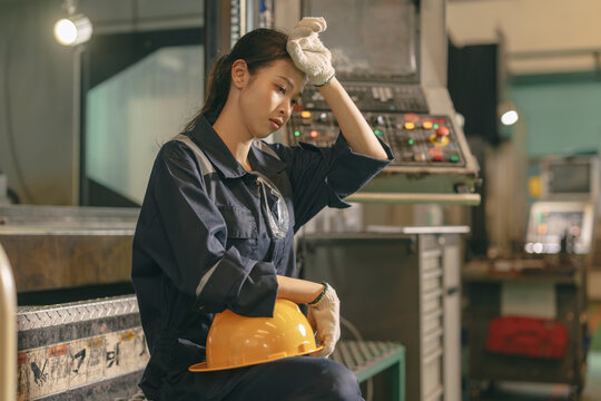 Young Asian woman worker hardwork in heavy industry, Engineer labor female tired fatigue exhausted