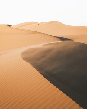 View of golden dunes rippling under a soft, hazy light, where shadows dance and the wind whispers secrets across the silent sands, Senek, Mangystau Region, Kazakhstan.