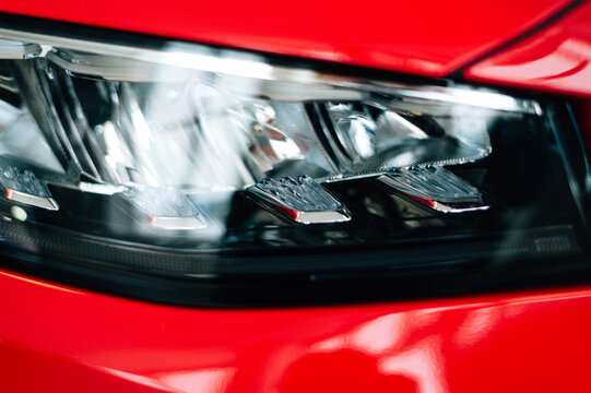 red car headlight, close up view, car dealing and manufacturing, cropped car image