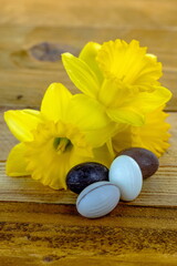 Uova di Pasqua di cioccolato su sfondo in legno con fiori