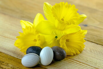 Uova di Pasqua di cioccolato su sfondo in legno con fiori