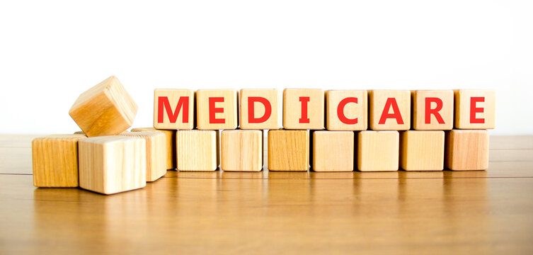 Medicare word symbol. Concept word Medicare on beautiful wooden blocks. Beautiful wooden table white background. Medical support help medicare word concept. Copy space.