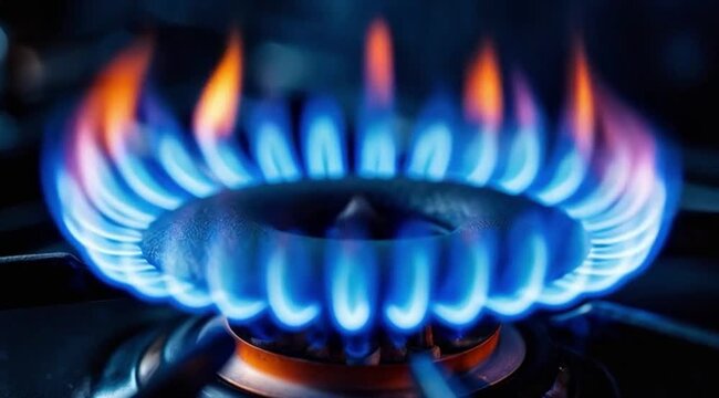 Gas burner flame glowing in dark kitchen environment  