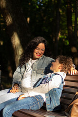 Fototapeta premium Joyful moment of happy mother spending time with her kid. Laughing, kissing, hugging, tickling. Parenthood moment.