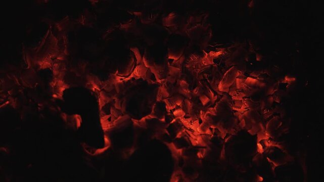 Burning coals in the dark, smoldering coal. Bright red sparks of fire.