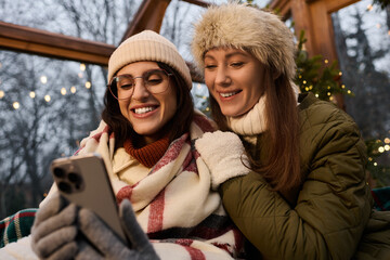 Cozy winter moments shared by a loving lesbian couple in warm attire during the holidays © LIGHTFIELD STUDIOS