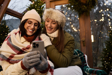 Fototapeta premium Cozy moments of a loving lesbian couple enjoying a winter evening together in festive style