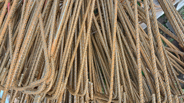 Close-up of rusty steel reinforcement bars at construction site. Industrial background of rebar for concrete foundation. Building material.