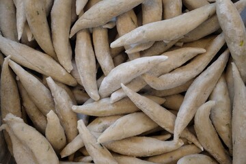 A close-up, high-angle shot showcasing a massive pile of frozen fish sticks, their pale, oblong forms creating a textured pattern, perfect for food-related projects and commercial use, empha