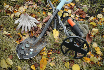 Obraz premium Professional tools for searching for treasures in dry grass. Metal detectors with a shovel and gloves for found coins