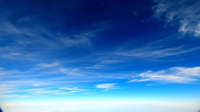Stunning aerial perspective of the atmosphere. Deep blue gradient sky and high cirrus clouds for travel and weather projects.