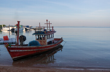 Fototapeta premium Traditional fishing boats resting on a quiet sandy beach under natural daylight, reflecting coastal life and local culture.