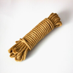 Coiled natural jute rope roll isolated on white background, rustic brown hemp cord for nautical...