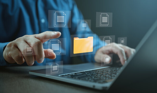 Businessman managing digital documents on laptop with virtual folder and file icons interface. Concept of DMS document management system, data organization, cloud storage, secure business workflow.