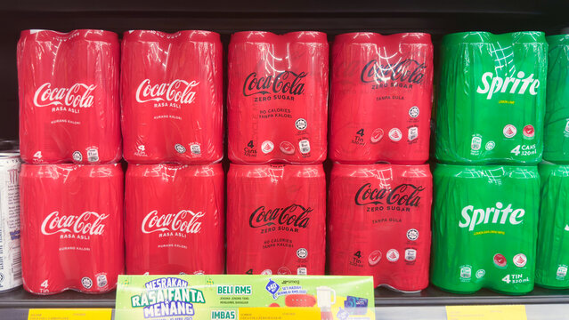 Coca-Cola and Sprite soft drink cans displayed on supermarket shelf in Penang Malaysia