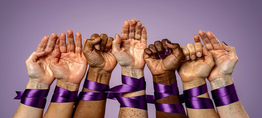 A group of diverse hands with purple ribbons symbolizing unity and awareness