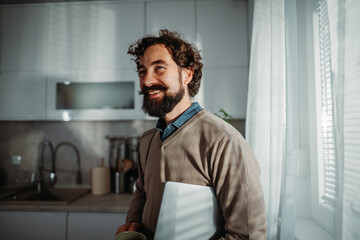Fototapeta premium Smiling man working from home in morning light