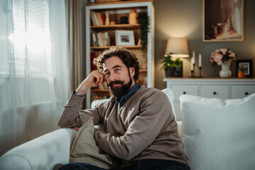 Fototapeta premium Man relaxing on sofa in living room at home