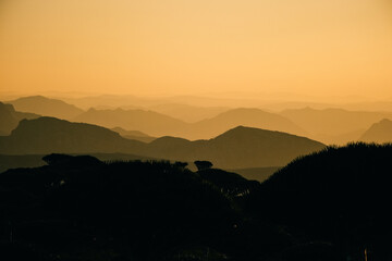 Fototapeta premium Evoking serene views. Hazy mountain ranges fade into tranquil valleys illuminated by gentle sunlight
