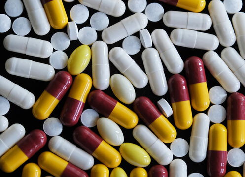 Large number of multi coloured pills, tablets or capsules. Prescription medicine, medication or drug misuse. Illness health treatment and cure  