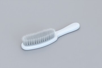 Brush with delicate bristles resting on a smooth gray surface, showcasing simplicity and elegance in design