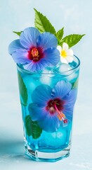 Refreshing blue tropical cocktail in a glass with ice, mint, and bright hibiscus flowers.