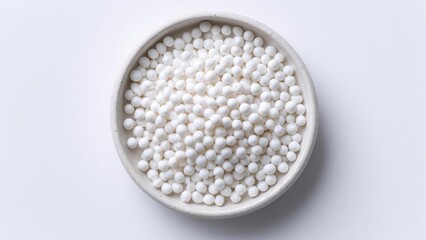 A bowl filled with many small white spherical beads. Concept White Bead Bowl, Minimalist Still Life, Macro Close-Up, Studio Lighting, Soft Color Palette