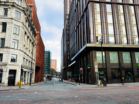 City Oxfrod Rd street scene in Manchester with modern glass buildings and pedestrians in a busy urban setting