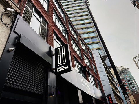 Urban street scene in Manchester with brick buildings and a BH Coors sign, BrickHouse Social