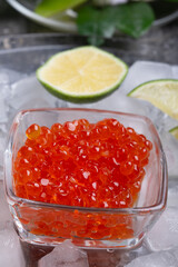  fresh red  salmon caviar with lime around ice. macro shot.  Protein luxury delicacy  healthy food. close up