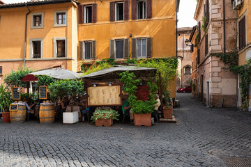 Cozy old street with tables of restaurant in Trastevere in Rome, Italy. Trastevere is rione of...