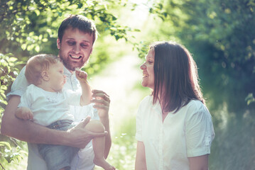 family with baby outdoors in warm natural sunlight