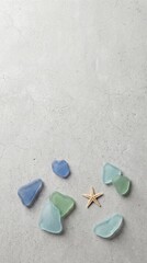 Fototapeta premium Multi colored sea glass and starfish on gray stone background