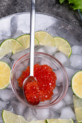  fresh red  salmon caviar with lime around ice. close up.  Protein delicacy  healthy food