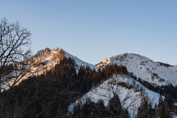 夕暮れの雪山と雪解けの風景 / Snowy mountains at sunset and the landscape of thawing snow
