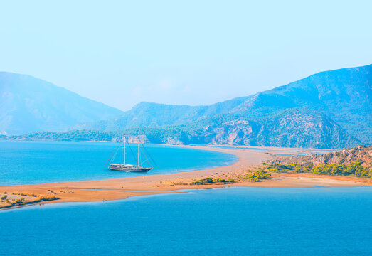 Black gulet anchored with rainbow at the Aegean sea - Panoramic view of iztuzu beach  - Dalyan, Turkey