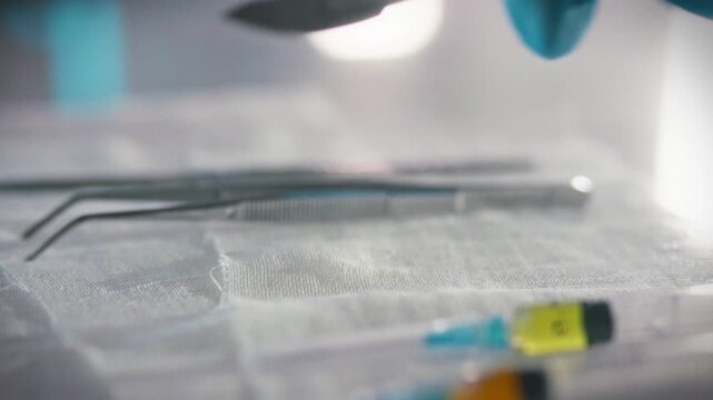 Surgeons hands carefully retrieve sterile scalpel from table laden surgical instruments, including tweezers syringe filled anesthesia, hospital operating room, preparing for precise medical operation