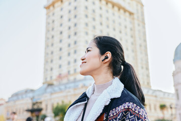 Headphones, woman and city outdoors fashion listening in daylight captures urban lifestyle with jacket and fleece, a confident moment amid skyline and street scenes © SHOTPRIME STUDIO