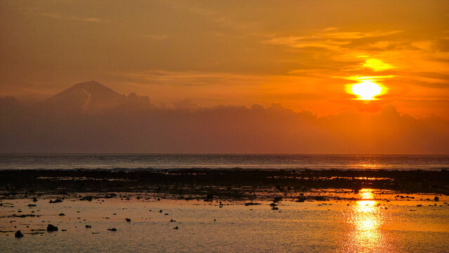 Tranquil sunset casting shimmering reflections over coastal sands Gili Trawangan Sunset