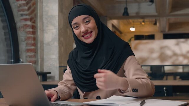Happy business woman in hijab invite office businesswoman welcome gesture hire job invitation smiling looking at camera friendly Arabian girl Muslim islamic female working laptop in office come here